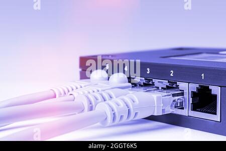 close-up of part of network equipment on white background with connected colored ethernet cables Stock Photo