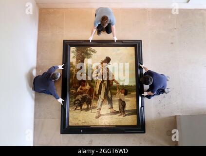 File photo dated 06/04/17 art technicians (from the left) Andy Cavanagh, Angus Wolf and Paul McCall moving 'The Beggar at Ornans' (1868) by French Realist Gustave Courbet, one of the most recognisable paintings at the Burrell Collection, Glasgow prior to the museum renovation. An art collection amassed by a shipping magnate is to go back on show to the public in March next year after a £68.25 million museum renovation. Issue date: Friday September 3, 2021.