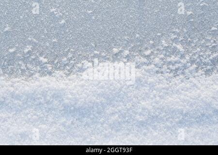 Close-up of snow and snowflakes on ice in the winter, viewed from above. Abstract full frame textured background. Copy space. Top view.