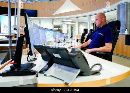 Karlsruhe, Germany. 18th Aug, 2021. Mike Reddmann, power plant foreman at the energy company EnBW, sits in front of screens in the control centre in unit 8 of the Rheinhafen steam power plant in Karlsruhe (RDK 8). Everyday life in a power plant is routine. The tension rises when malfunction reports are received. For power plant workers, there is an additional complication: constant shift changes and night work. Credit: Uwe Anspach/dpa/Alamy Live News Stock Photo
