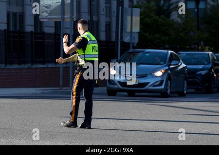 Police officer directs traffic around closed downtown streets and highways in the aftermath of Tropical Storm Ida. Stock Photo