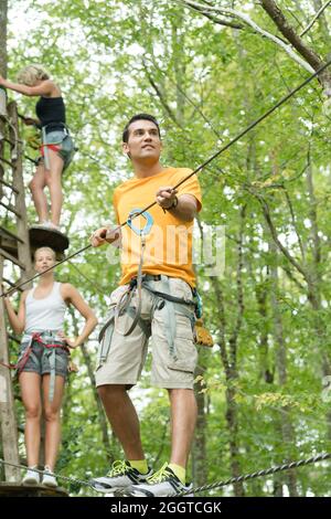 man in adventure park on tree top Stock Photo