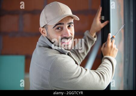 man installing roller shutter on window Stock Photo