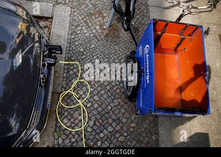 Berlin, Germany. 02nd Sep, 2021. An electric car stands at a charging station in a residential area in the Prenzlauer Berg district. An Avocargo e-bike (r) stands in front of it. Credit: Carsten Koall/dpa/Alamy Live News Stock Photo