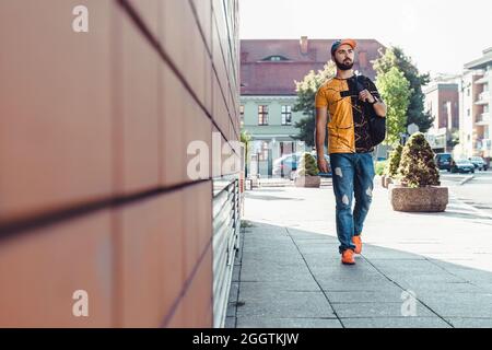 Guy walking down on street. Young man in casual style Stock Photo