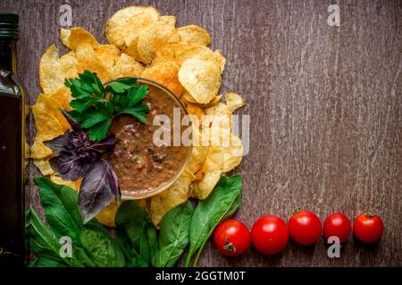 Potato chips with dipping sauce on a wooden table. Unhealthy food on a wooden background. Stock Photo