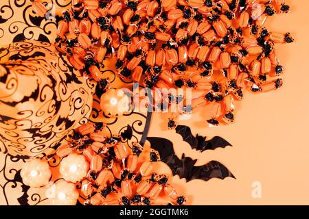 Halloween card - pumpkins, hat, candy and candles on an orange background for advertising, congratulations or sale. Stock Photo