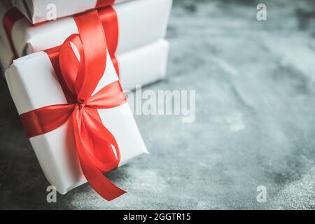 Christmas gift with red ribbon on the gray concrete background. Christmas and New Year background. Stock Photo