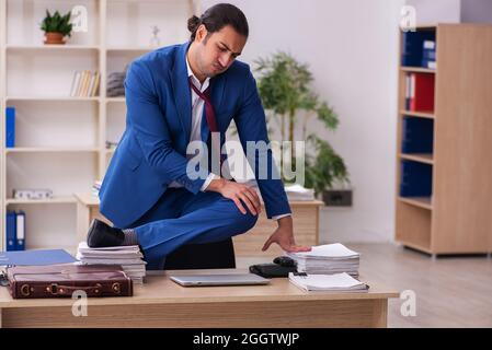 Young businessman employee doing yoga exercises during break Stock Photo