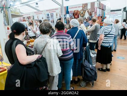 Back view of line of customers at kiosk at Orthodox fair, Moscow, Russia Stock Photo