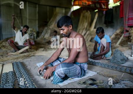 Non Exclusive: DHAKA, BANGLADESH, SEPTEMBER 2, 2021: An  craftsmen manufactures idol figures during the ongoing preparations for the idol of Goddess D Stock Photo