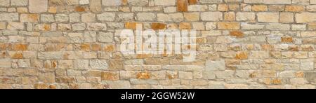 Old coarse panoramic stone wall in beige, ocher and brown Stock Photo
