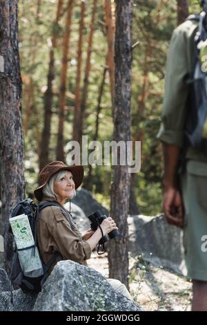 Senior man holding binoculars and smiling Stock Photo - Alamy