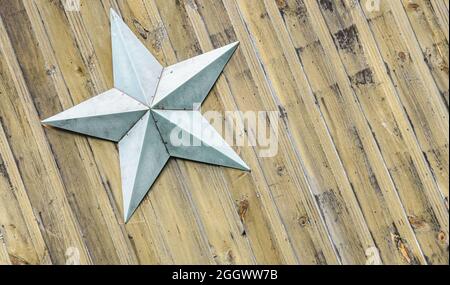 Light blue star on a background of diagonal rustic yellow pine beadboard. Copy space. Stock Photo