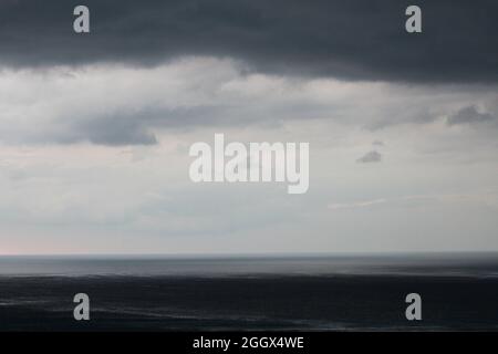 Dark sky and dramatic black cloud before rain. rain comming in the beach Stock Photo