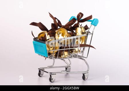 Golden bells with a ribbon bow, in the shopping basket.  Stock Photo