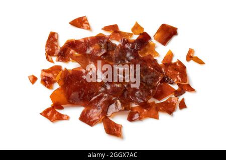 Heap of brown Shellac flakes isolated on white background Stock Photo