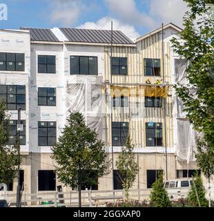 Workers on a scaffold working on new construction Stock Photo