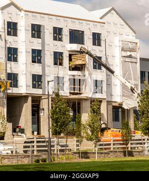 Workers on s cherry picker at a construction site Stock Photo