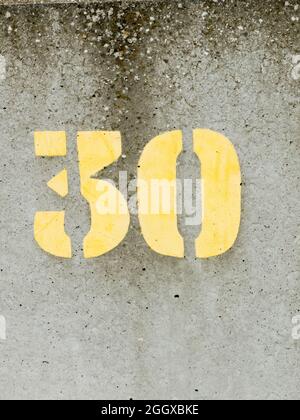 Stencilled yellow paint number 30 on a concrete sea wall Stock Photo