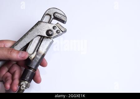 Adjustable wrench in hand on a white background in the photo on the left Stock Photo