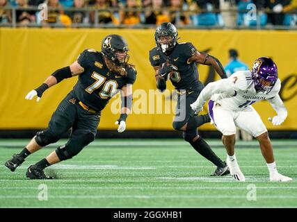 Charlotte, North Carolina, USA. 3rd Sep, 2021. Appalachian State Mountaineers running back Camerun Peoples (6) looks around the block of offensive lineman Cooper Hodges (70) on East Carolina Pirates linebacker Jeremy Lewis (11) the 2021 Duke's Mayo Classic between Appalachian State and East Carolina at Bank of America Stadium in Charlotte, North Carolina. Rusty Jones/Cal Sport Media/Alamy Live News Stock Photo