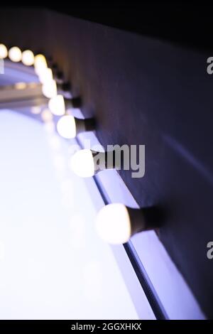Circus lights in a row on red ceiling. Lamp hanging from the ceiling in the building. Arranged in a long line Stock Photo
