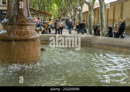 Palma de Mallorca, Spain; april 23 2021: Close-up of the stone fountain in the historic center of Palma de Mallorca with people out of focus in the ba Stock Photo