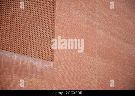 A modern red brick architectural structure with in built pattern or texture due to the positioning of the bricks. Stock Photo