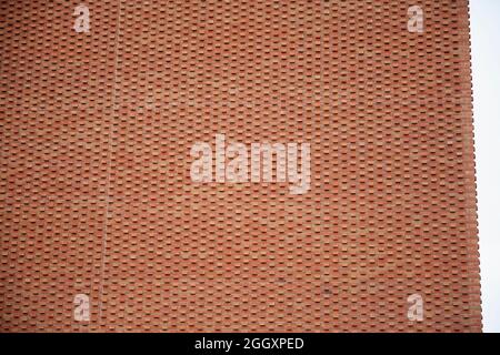 A modern red brick architectural structure with in built pattern or texture due to the positioning of the bricks. Stock Photo