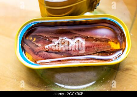 Storebought canned anchovies in oil in can with open lid wild caught macro closeup view showing texture of fillets Stock Photo
