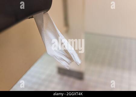 Clean bathroom interior with closeup of public restroom white toilet paper hanging with tissue rolls in stall Stock Photo