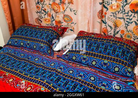 Bedroom with closeup of bohemian comforter queen set with blue red ethnic vintage retro floral warm bed comforter made of cotton bedding and floral fl Stock Photo