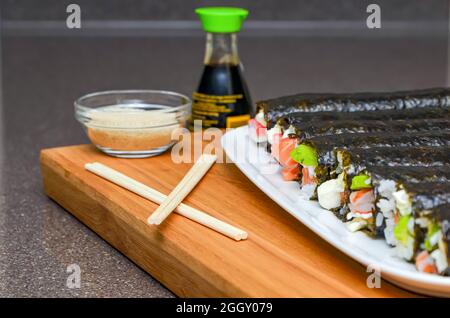 Sushi roll with salmon and avocado. Beautiful macro, shallow depth of field, not sliced rolls in a plate Stock Photo