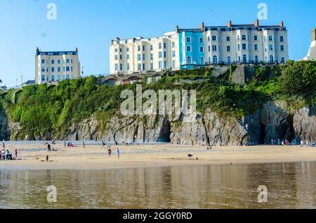 Colourful buildings on the headland above The South Beach at Tenby in Wales seen at low tide. Stock Photo