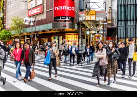 Osaka, Japan - April 13, 2019: Modern buildings road near station with traffic of people crossing street to famous arcade and business signs Stock Photo