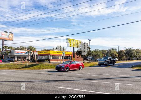Destin, USA - January 13, 2021: Destin city town view from Emerald Coast parkway road street with stores shops restaurants for Waffle House and PepBoy Stock Photo