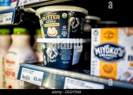 Herndon, USA - March 25, 2021: Closeup of hand holding vegan food packaged Miyoko's sea salt cultured butter made with oat milk, nut free vegetable sp Stock Photo