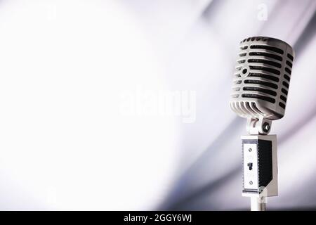 Stand with a retro microphone. Microphone on a tripod. Performance of the artist with vintage microphone. Scene with a microphone. Stock Photo