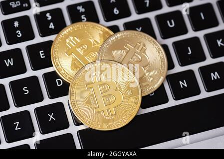 Golden coins with bitcoin symbol on laptop keyboard Stock Photo