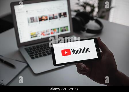 Wroclaw, Poland - JUN 17, 2021: Man holding device with YouTube logo on screen. YouTube is most popular video service developed by Google. Stock Photo