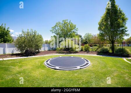 In-ground trampoline on a lawn at the backyard in Utah Stock Photo