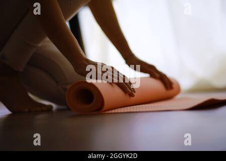 Beautiful athletic girl doing yoga exercises enjoy meditation at home. No stress, healthy habit, anxiety relief concept. Lotus. Stock Photo