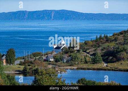 A view of Upper Island Cove, Newfoundland, a small fishing village with a sheltered harbor surrounded by small fishing boats. Stock Photo