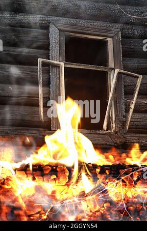Wooden house after the fire. Coals on the logs. The ashes of the house from fire. Burnt destroyed cottage. Stock Photo