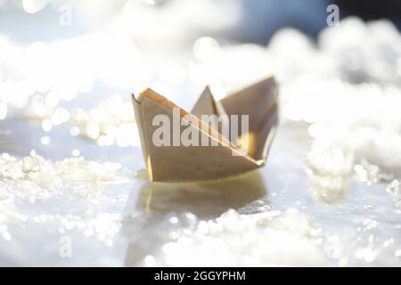 Little Model Fishing Boat In Water With Torn Paper On A Blue