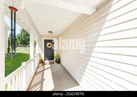Home front door exterior with colorful potted flowers and wreath Stock Photo