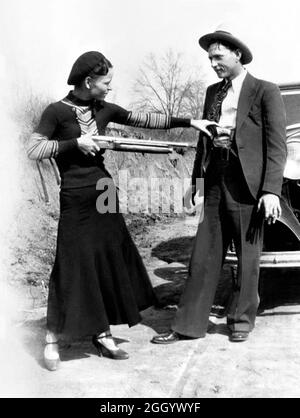 1934 , Arkansas , USA : The famous gangsterns  BONNIE PARKER  ( 1910 - 1934 ) and CLYDE BARROW ( 1909 - 1934 ). Contrary to popular belief the two never married. They were in a long standing relationship. Posing in front of a 1932 Ford V8 automobile. Recovered from Bonnie and Clyde after their deaths on May 23, 1934 . Unknown photographer . - OUTLAWS - KILLER - ASSASSINO - delinquente - criminalità organizzata  - GANGSTERN - Bos - CRONACA NERA - CRIMINALE - car - automobile - hat - cappello - fucile - arma - gun - rifle - shoes - scarpe ---  Archivio GBB Stock Photo