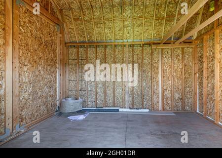 Interior of an empty shed with wood frameworks and concrete flooring Stock Photo