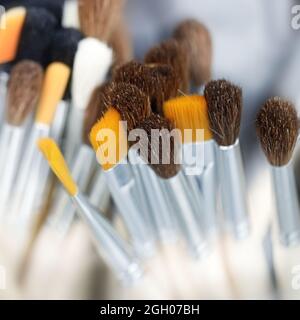 Artist's brushes for painting. Close up of different new painting brushes on dark background with bokeh, soft focus. Stock Photo